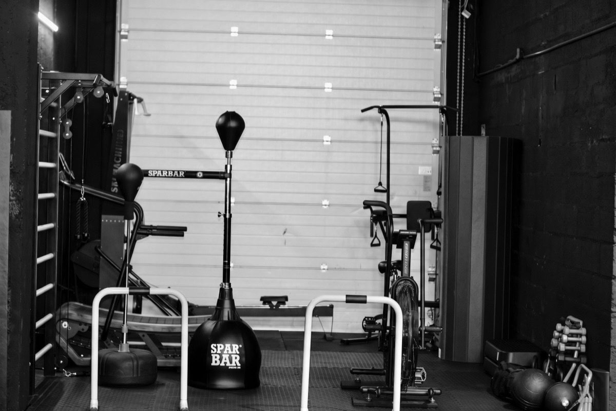 Salle de préparation physique de L'Atelier du Combat à Seichamps : rameur, vélo à air, poulies, SparBar et haltères